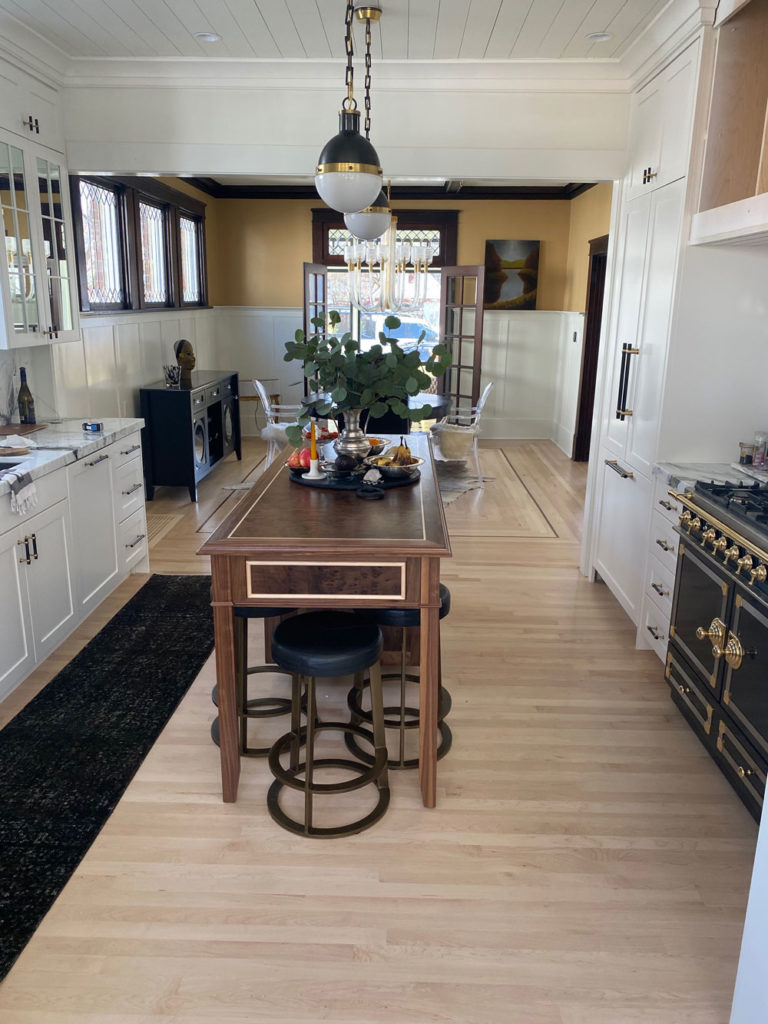 light colored hardwood floors in kitchen with dark colored island