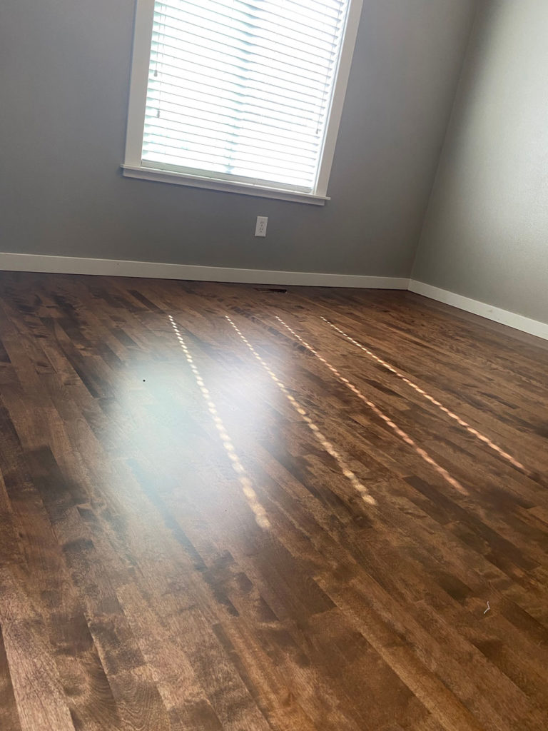 dark brown hardwood floors in clean bedroom