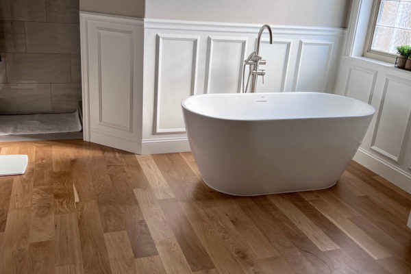 oak hardwood floors in modern bathroom with stand alone bathtub