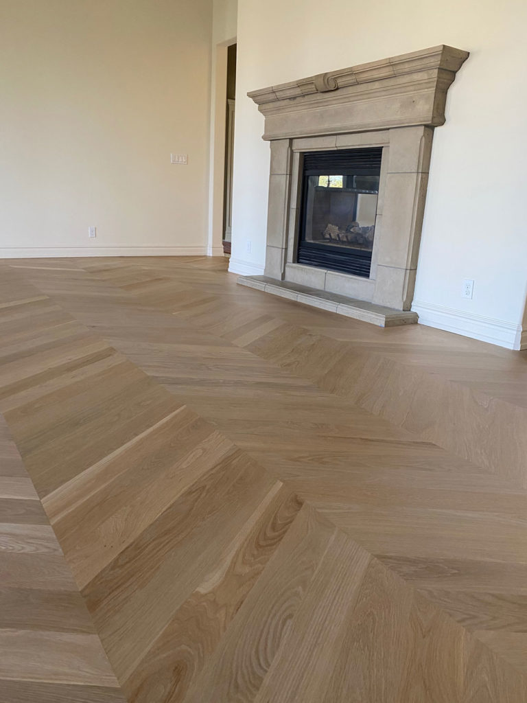 patterned oak hardwood floors in living room with fireplace
