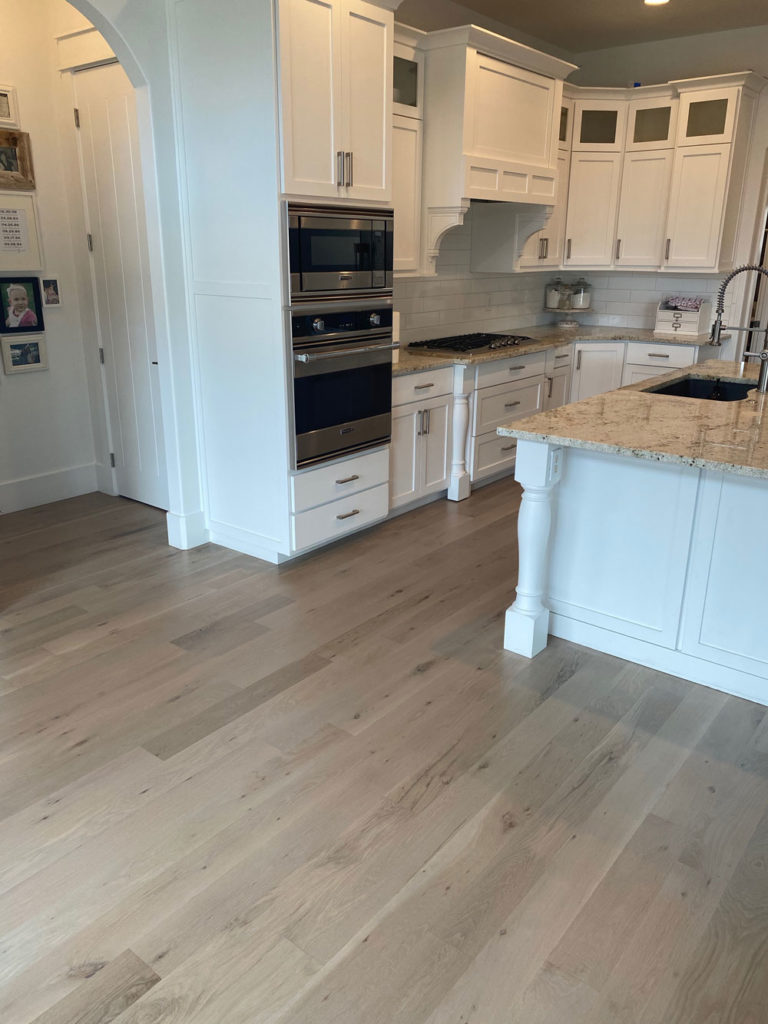grey oak hardwood flooring in white kitchen