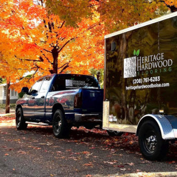 blue Dodge Ram truck with black trailer with Heritage Hardwood label